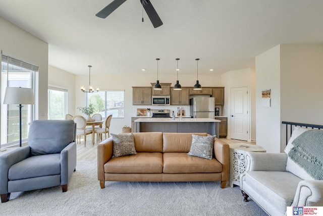 living area featuring ceiling fan with notable chandelier and recessed lighting