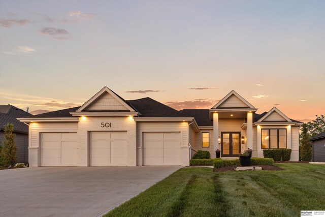 501 S 243rd St, Waterloo, NE 68069 - view of front facade with french doors, a garage, concrete driveway, a front yard, and brick siding