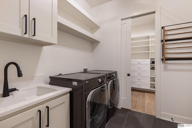 501 S 243rd St, Waterloo, NE 68069 - clothes washing area featuring washing machine and dryer, cabinet space, and dark tile patterned floors