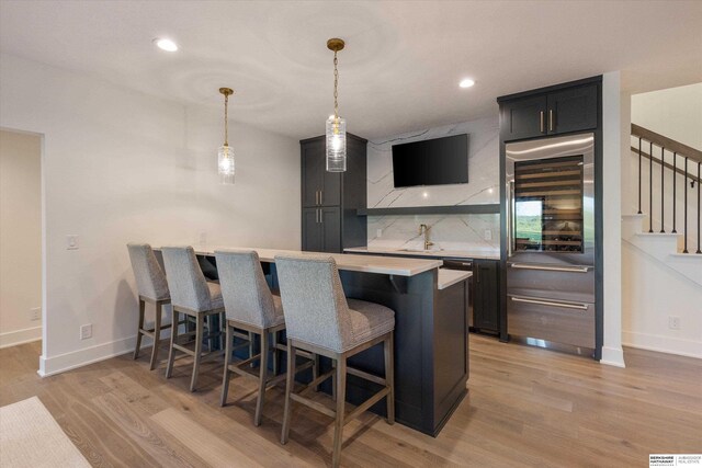 501 S 243rd St, Waterloo, NE 68069 - bar area featuring light wood finished floors, tasteful backsplash, stairs, baseboards, and recessed lighting