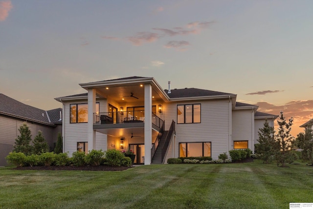 501 S 243rd St, Waterloo, NE 68069 - back of property at dusk featuring ceiling fan, stairs, a lawn, and a balcony