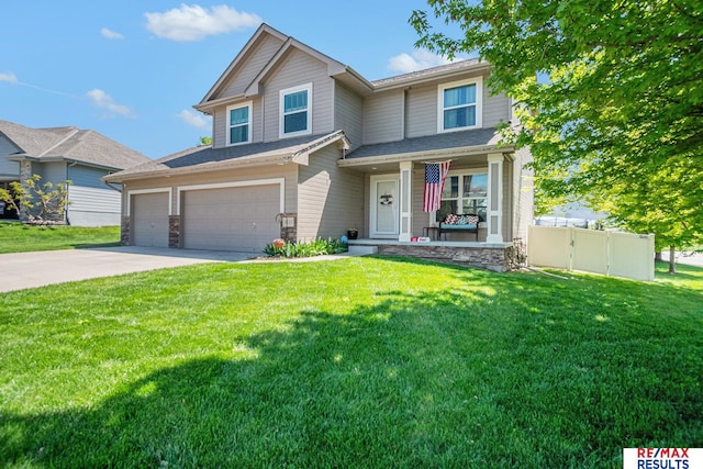 craftsman-style home with covered porch, fence, stone siding, concrete driveway, and a front lawn