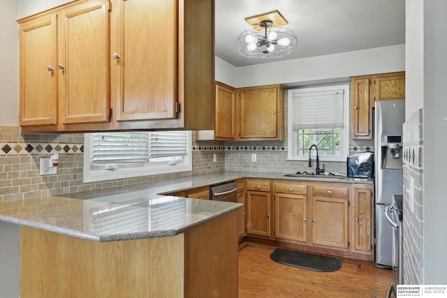 6523 Emmet St, Omaha, NE 68104 - kitchen with a peninsula, a sink, light wood-type flooring, backsplash, and light stone counters