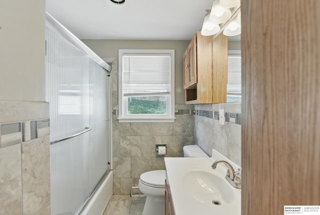 6523 Emmet St, Omaha, NE 68104 - full bathroom with tile patterned floors, tile walls, toilet, and vanity