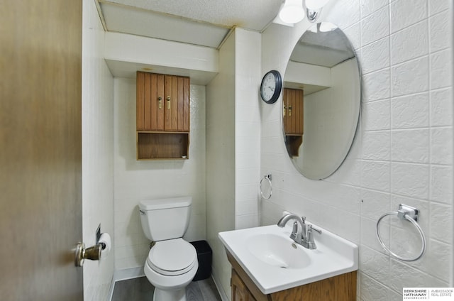 6523 Emmet St, Omaha, NE 68104 - bathroom featuring tile walls, toilet, and vanity