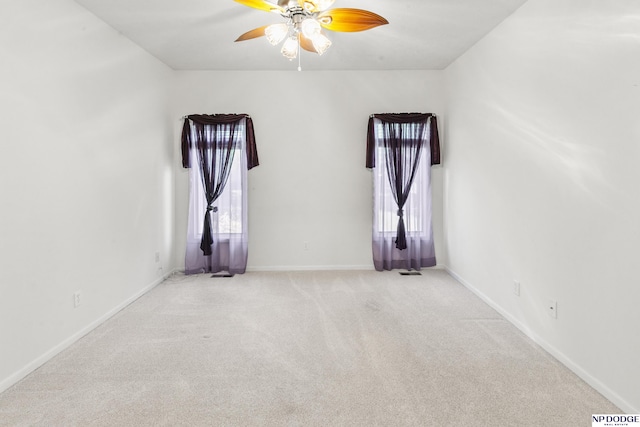empty room with light carpet, baseboards, and a ceiling fan