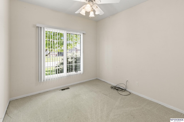 carpeted empty room featuring visible vents, baseboards, and a ceiling fan