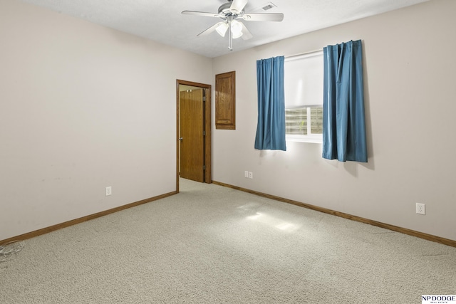 carpeted empty room with ceiling fan and baseboards