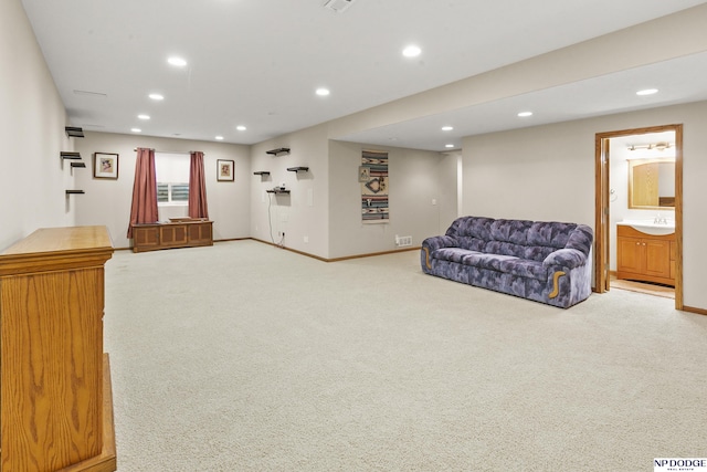 carpeted living area with baseboards and recessed lighting