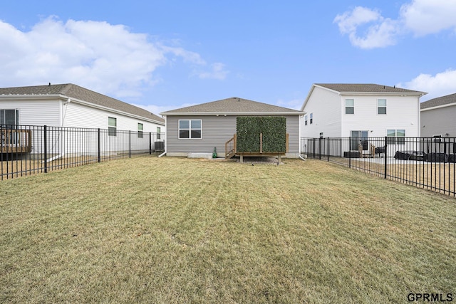 rear view of property with a lawn, central AC, and a fenced backyard