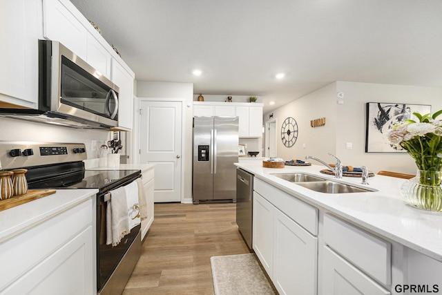 kitchen with light wood-style flooring, a sink, white cabinets, appliances with stainless steel finishes, and recessed lighting