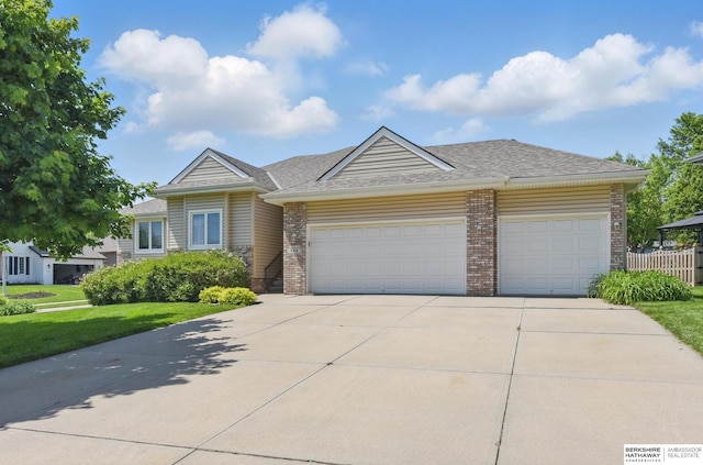 view of front facade featuring an attached garage, brick siding, concrete driveway, and a shingled roof