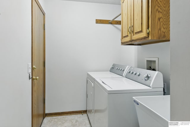 laundry area with washing machine and dryer, cabinet space, and baseboards