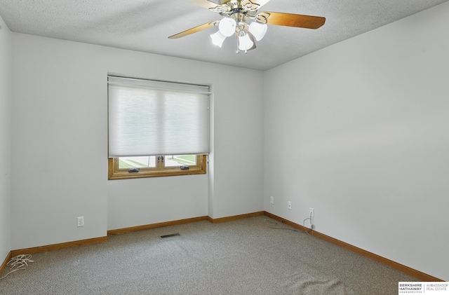 carpeted spare room with a ceiling fan, baseboards, and a textured ceiling