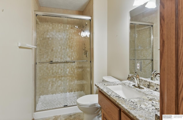 bathroom with toilet, a shower stall, and vanity
