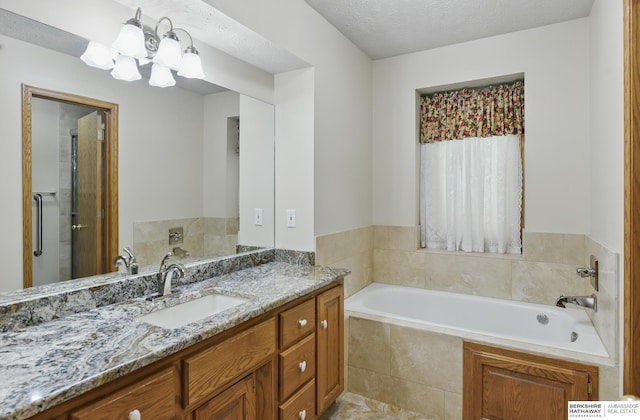 bathroom with a bath, vanity, and a chandelier