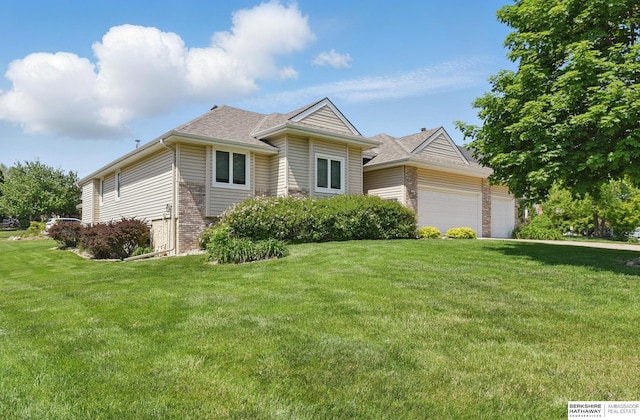 view of front of home featuring brick siding, a garage, a front yard, and roof with shingles