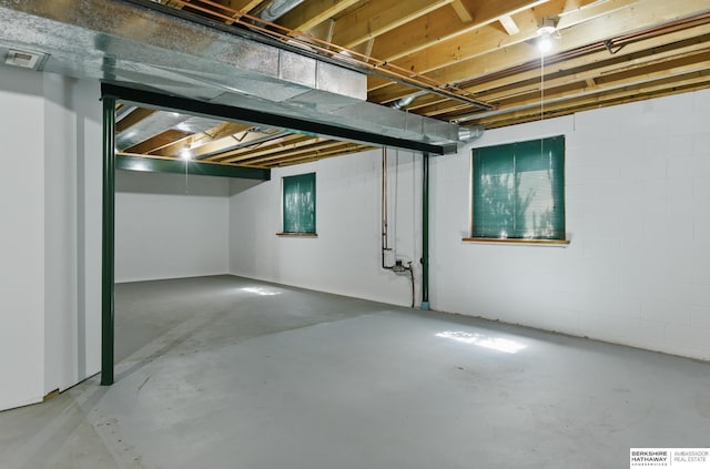 unfinished basement featuring concrete block wall