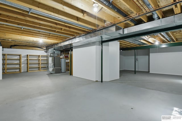 unfinished basement featuring gas water heater and heating unit