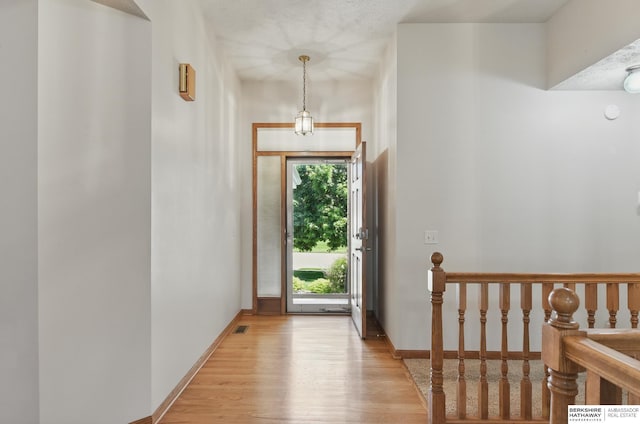 foyer entrance with light wood-style flooring and baseboards