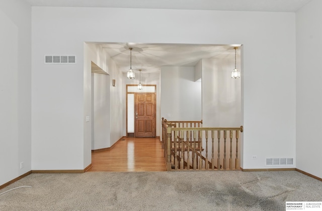 corridor with an upstairs landing, carpet, and baseboards