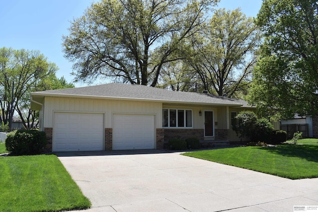 ranch-style house featuring an attached garage, a shingled roof, a front lawn, brick siding, and driveway