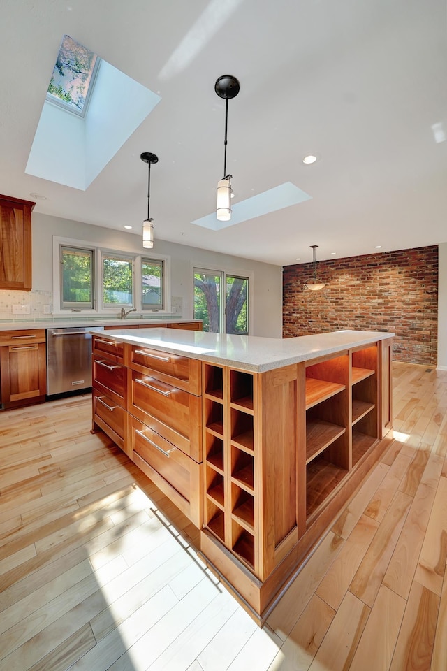 kitchen featuring light wood finished floors, open shelves, a skylight, and dishwasher
