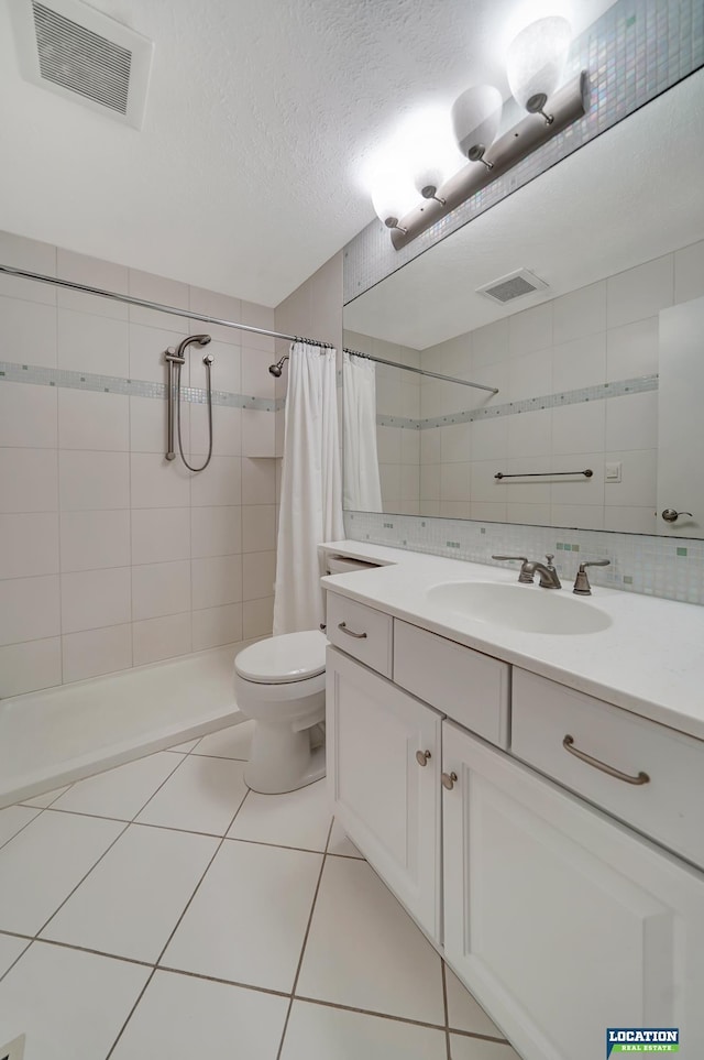 full bath featuring tile patterned flooring, tiled shower, and visible vents