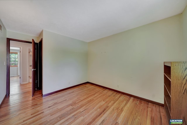 unfurnished room featuring light wood finished floors and baseboards
