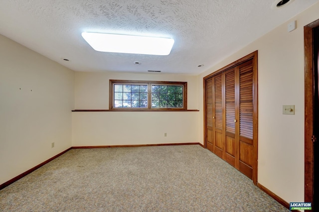 unfurnished bedroom featuring carpet, baseboards, and a textured ceiling