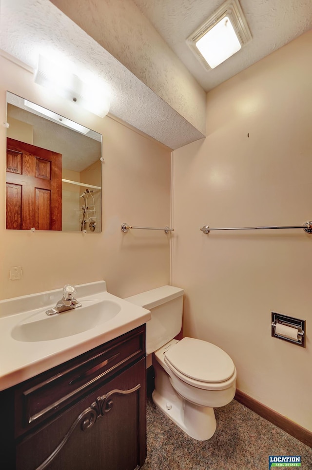 full bathroom featuring toilet, baseboards, a shower, and vanity