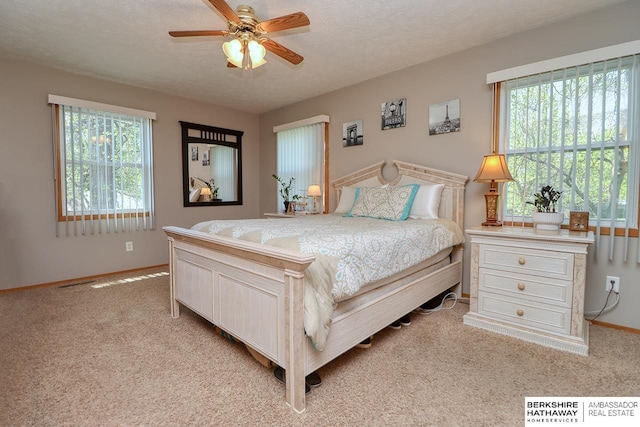 bedroom with light colored carpet, a textured ceiling, and baseboards