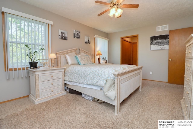 bedroom featuring light colored carpet, visible vents, baseboards, and ceiling fan