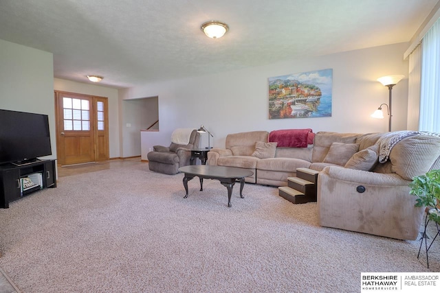 carpeted living room featuring stairs
