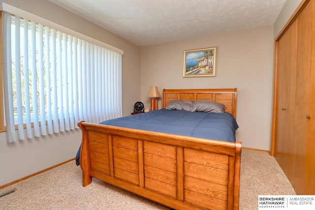 bedroom with multiple windows, light carpet, and a closet