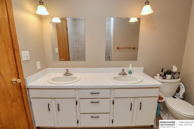 bathroom with double vanity, toilet, and a sink