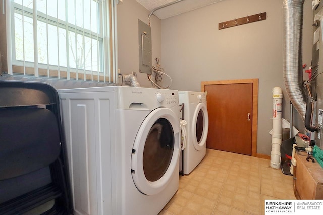 washroom featuring light floors, washing machine and dryer, laundry area, and electric panel