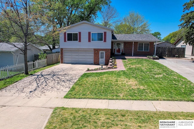 split level home with concrete driveway, brick siding, fence, and a garage