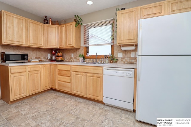 kitchen featuring light brown cabinets, white appliances, a sink, backsplash, and light countertops