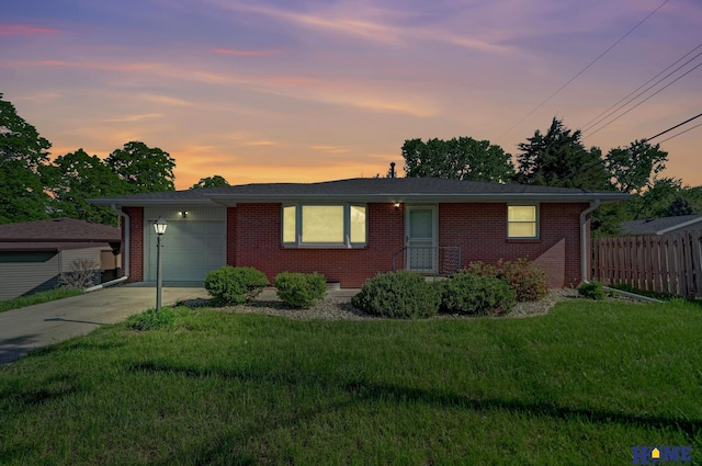 ranch-style home with a yard, brick siding, fence, an attached garage, and concrete driveway