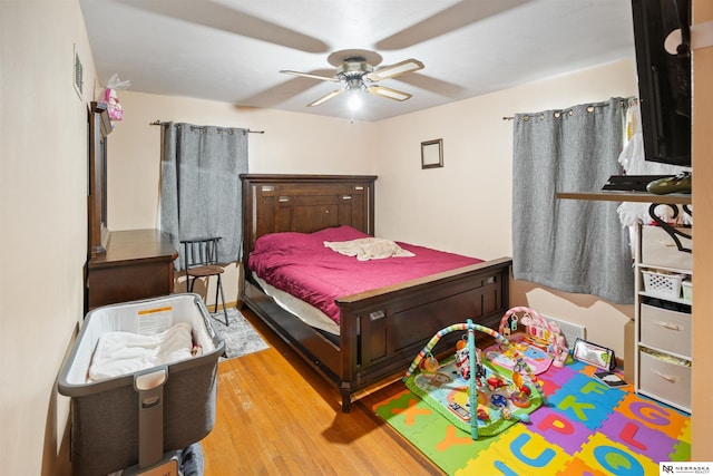 bedroom with a ceiling fan, visible vents, and wood finished floors