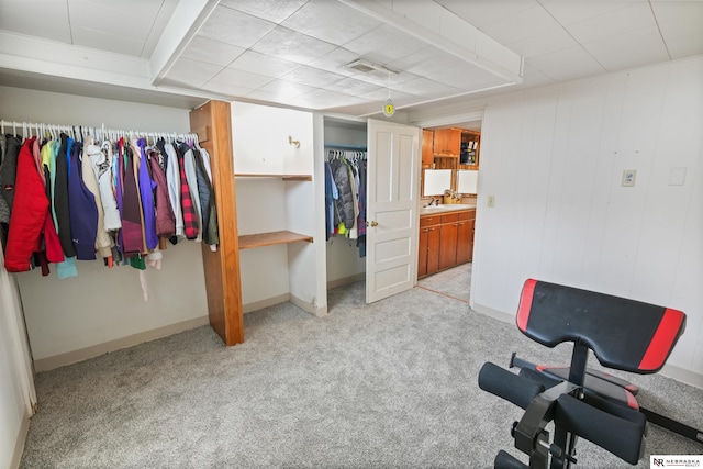 interior space with baseboards, light carpet, visible vents, and a sink