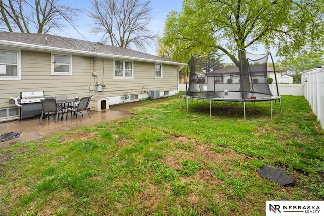 back of house with a trampoline, a yard, a patio, a fenced backyard, and cooling unit