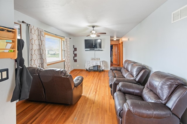living area featuring ceiling fan, baseboards, visible vents, and wood finished floors