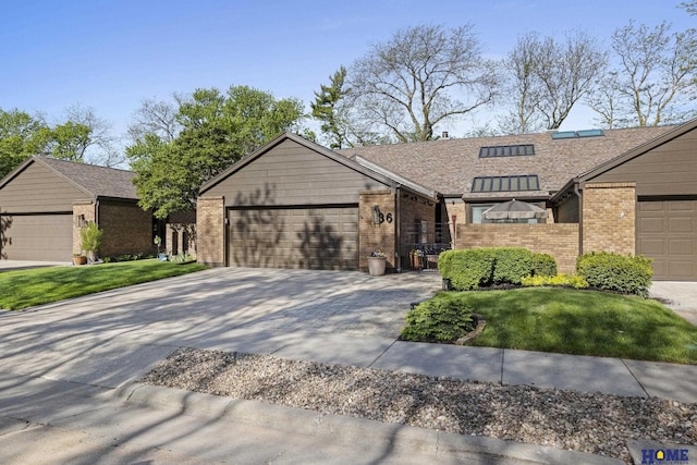 view of front of house featuring fence, an attached garage, brick siding, driveway, and a front lawn