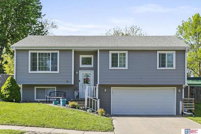 raised ranch with a garage and concrete driveway