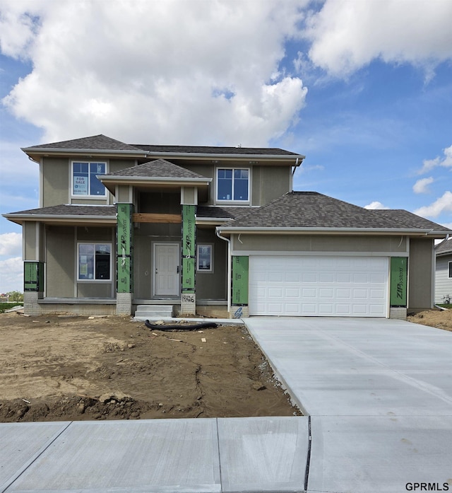 19826 Cinnamon St, Omaha, NE 68135 - prairie-style house featuring concrete driveway, stucco siding, an attached garage, and a shingled roof