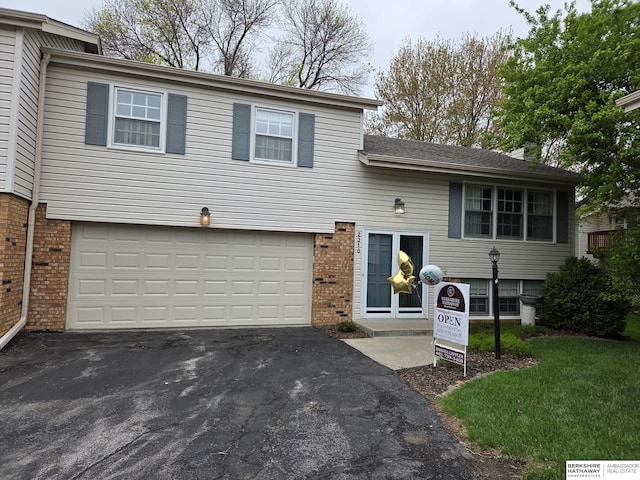 2318 S 119th Plz, Omaha, NE 68144 - tri-level home with brick siding, asphalt driveway, and a garage