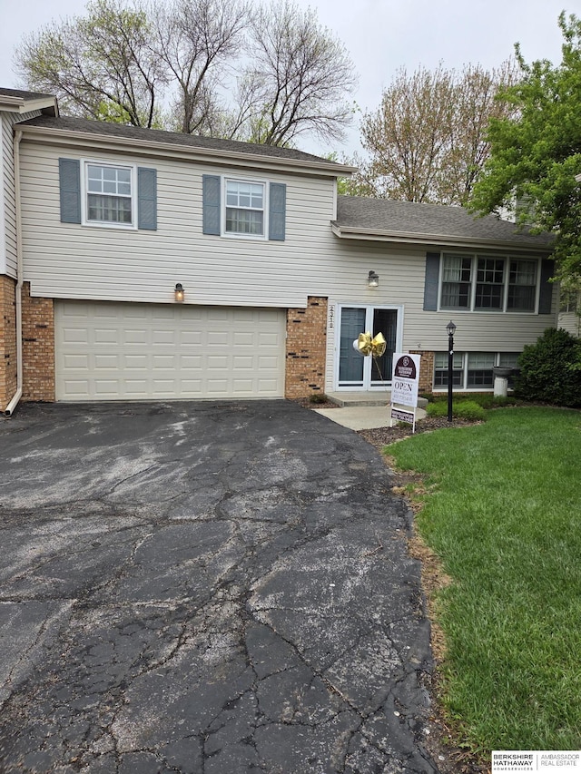 2318 S 119th Plz, Omaha, NE 68144 - view of front of home with asphalt driveway, brick siding, and a garage