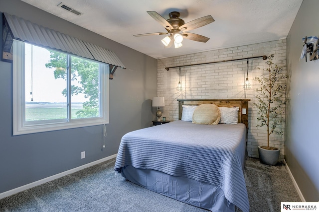 carpeted bedroom featuring brick wall, baseboards, and ceiling fan